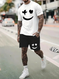 Street style shot of a white t-shirt and black shorts featuring a graffiti smiley face print