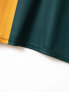 Detailed close-up of dark green breathable polo shirt fabric with yellow contrast trim