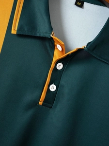 Detail of breathable polo fabric with green and gold color block and white buttons