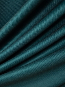 Close-up of dark green polo shirt fabric showing fine texture and silky luster