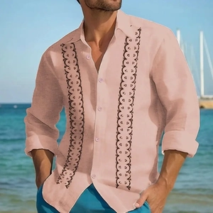 Men's relaxed long sleeve striped shirt in soft peach with black embroidery on a beach