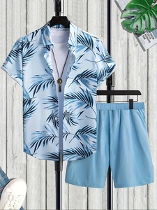 Flat lay of a men's light blue tropical palm print shirt and matching casual shorts set