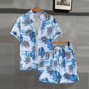 Detail of men's summer set featuring blue palm leaf print shirt and shorts on a hanger