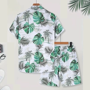 Detail of men's summer Hawaiian set featuring green tropical palm leaf print on white fabric