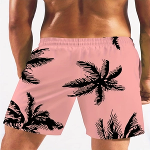 Detail view of pink Hawaiian swim trunks with black palm leaf prints and elastic waist