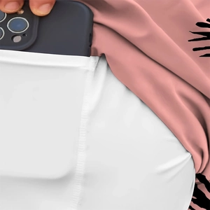Detail showing a white side pocket on pink patterned bedding holding a smartphone