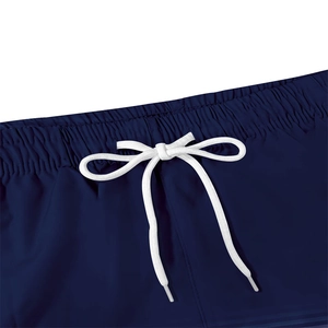 Close-up of navy blue beach shorts featuring elastic waistband and white drawstrings