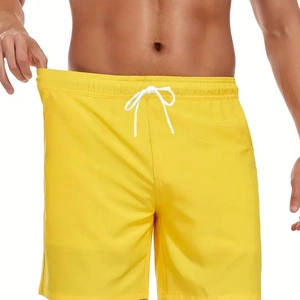 Detail of men's bright yellow swim trunks with elastic waistband and white drawstrings