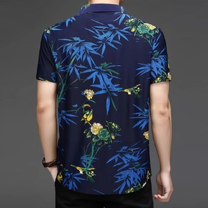 Dettaglio della stampa tropicale su camicia blu navy a maniche corte con uccelli e foglie
