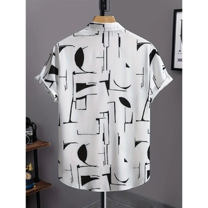 Dettaglio di una camicia a maniche corte con motivi geometrici neri su sfondo bianco