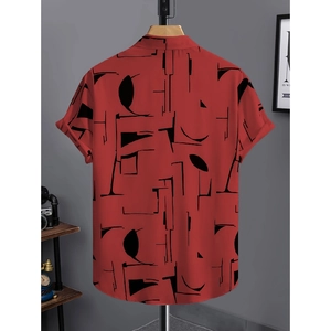Dettaglio camicia da uomo a maniche corte con motivi geometrici astratti rossi e neri
