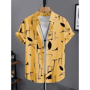 Dettaglio camicia gialla a maniche corte con stampe geometriche su appendino