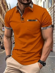 Detail of orange men's polo shirt featuring plaid pattern accents on collar and pocket