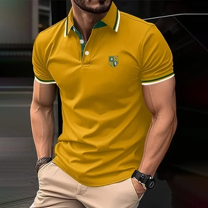 Close-up of mustard yellow men's polo shirt featuring striped collar and shield emblem