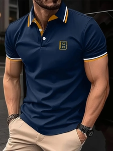 Close-up of navy men's polo shirt featuring yellow Brooklyn embroidery and striped collar