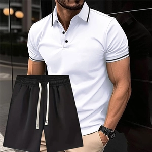 Dettaglio del colletto della polo bianca con strisce nere e pantaloncini con coulisse