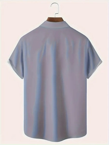 Rear view of light blue short-sleeved Hawaiian shirt with wood hanger on plain background