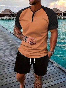 Detail of men's orange raglan Henley shirt with buttons and black drawstring shorts set