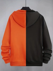 Detail of color-blocked hoodie showing orange and black back design with ribbed cuffs