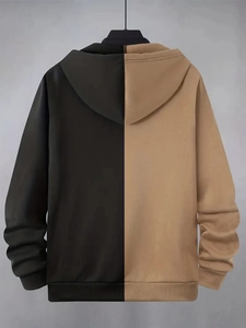 Detail view of the black and beige color-block stitching on the hooded sweatshirt fabric