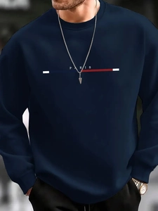 Détail d'un sweat bleu marine avec lettrage Paris et motif à rayures tricolores