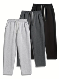 Three-pack men's drawstring sweatpants in black, dark grey, and light grey cotton fabric