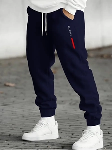 Detail of navy joggers showing white BALANCE lettering and elastic ribbed cuffs