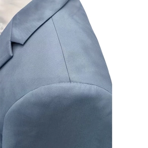 Close-up detail of smooth shoulder stitching and notch lapel on gray blue blazer jacket