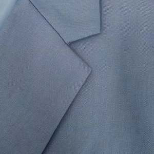 Detailed close-up of notched lapel and blue twill fabric texture on a slim fit blazer