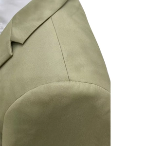 Close-up of olive green slim fit blazer showing fine twill fabric and shoulder seam detail