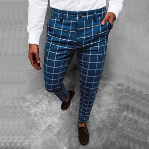 Detailed view of slim fit navy blue plaid trousers with classic white grid pattern on model