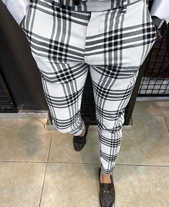 Detailed close-up of men's slim fit black and white plaid trousers with premium texture