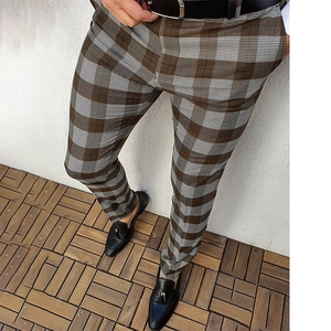 Detail shot of men's slim fit plaid trousers in brown and white with leather belt
