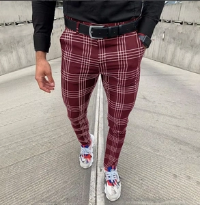 Detail of burgundy plaid trousers showing slim fit design and checkered pattern texture