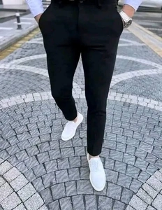 Close-up of men's slim fit black checkered casual trousers with smooth drape fabric