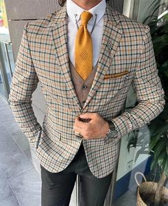 Detail of slim fit plaid blazer featuring orange and grey wool texture with elegant lapel pin