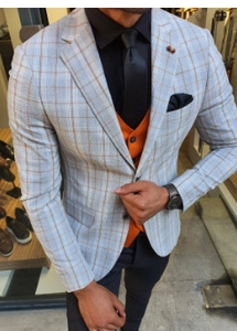 Detail of light blue windowpane plaid suit jacket with orange vest and tie