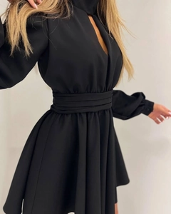 Detailed view of women's black dress featuring waist pleats and a cutout neckline design