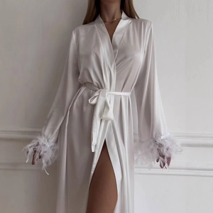 Détail du peignoir en satin blanc élégant avec poignets en plumes et ceinture nouée