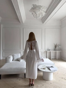 Vue détaillée du peignoir en satin blanc avec dentelle florale et manches bordées de plumes