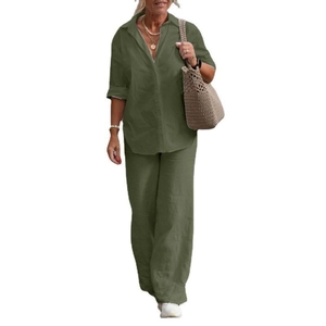 Detail of olive green linen texture on long-sleeve buttoned shirt and wide-leg trousers