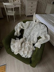 Detail of white paisley lace dress showing intricate hollow-out texture on fabric