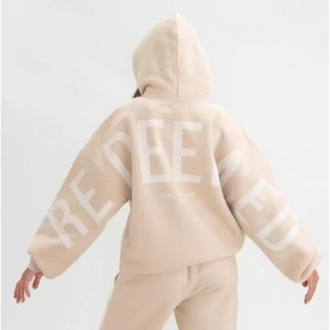 Back view of beige oversized hoodie featuring large white REDEEMED puff print text
