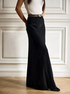 Detail of elegant black satin high waist fishtail skirt with slim brown belt