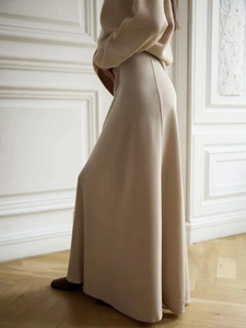 Detail of elegant beige satin maxi skirt with high waist and fluid silk-like texture