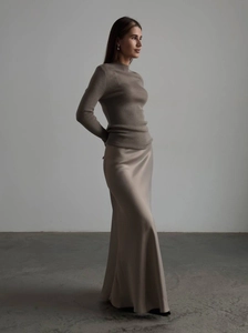 Close-up detail of champagne satin high waist maxi skirt and brown knit sweater