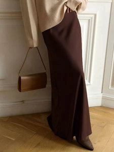 Close-up of elegant high-waisted dark brown satin maxi skirt with a graceful drape