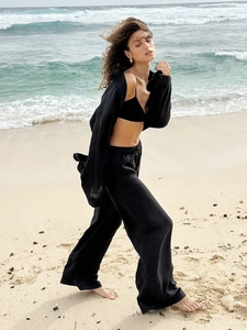 Detail of a black three-piece beach set featuring long-sleeved shirt and wide-leg pants