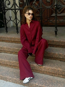 Detail shot of wine red cotton linen lounge set featuring loose shirt and wide trousers