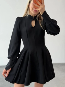 Detail of elegant black mini dress featuring a keyhole neckline and puff lantern sleeves